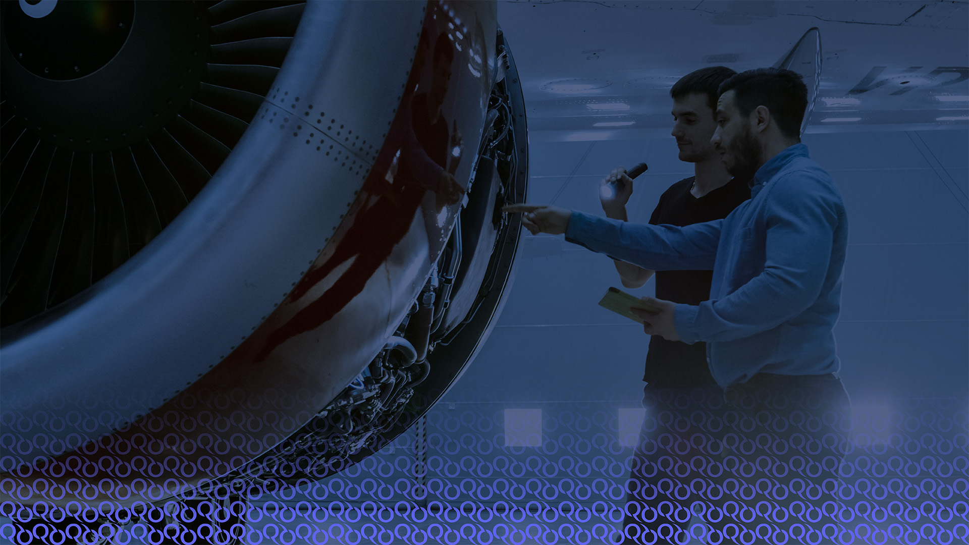Two engineers looking at an aircrafts engine